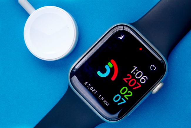 En smart klocka från apple mot blå bakgrund.